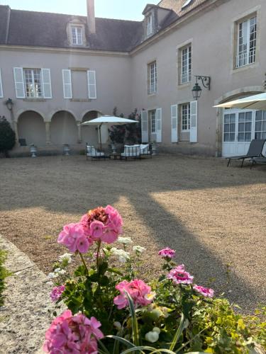 a house with pink flowers in front of it at Domaine familial du château de Ragny in Savigny-en-Terre-Plaine
