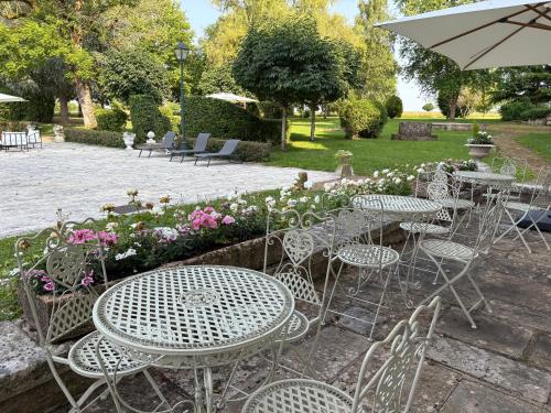 a group of tables and chairs in a garden at Domaine familial du château de Ragny in Savigny-en-Terre-Plaine