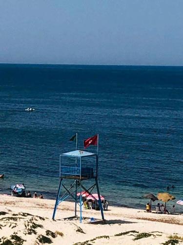 a life guard chair on a beach with the ocean at Appartement S2 cotè mer Soviva Kantaoui in Hammam Sousse