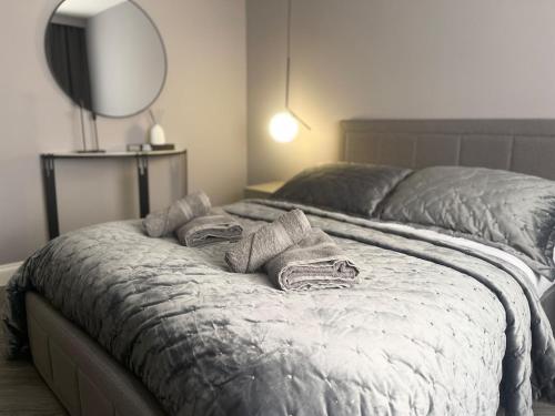 a bedroom with a bed with two pillows and a mirror at Luxury Retreat with Private Hot Tub in Cawston