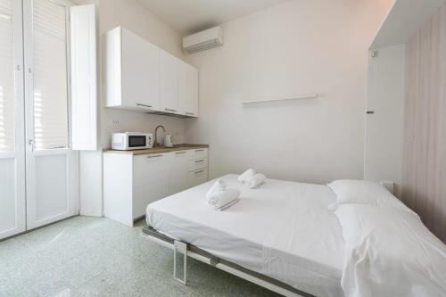 a white bedroom with a bed and a microwave at Il Nido di Marta - Nido Verde in Florence