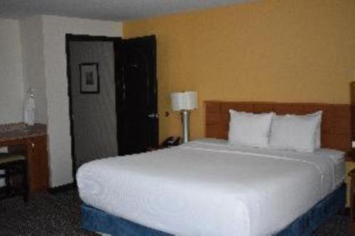 a bedroom with a large white bed and a desk at Studio 6 Carlsbad CA in Carlsbad