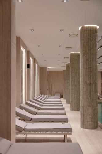 a row of benches in a room with columns at Hotel Tara Becici in Budva