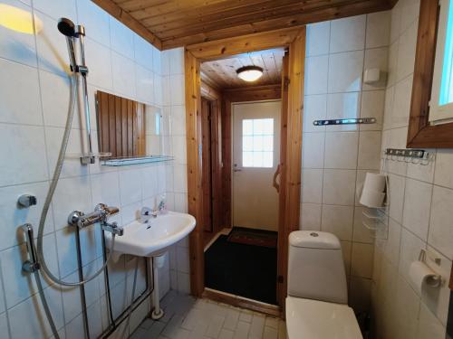 Un baño con lavabo, inodoro y ducha. en Hulhavantuvat 1, en Syöte