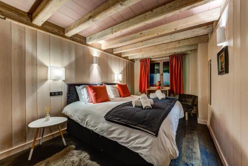 une chambre avec un grand lit dans une pièce avec des plafonds en bois dans l'établissement Chalet Hibou, à Chamonix-Mont-Blanc