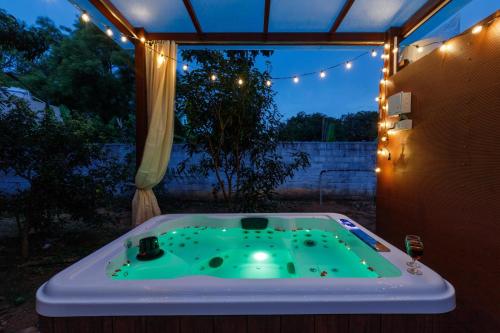 a jacuzzi tub in a backyard at night at White Lotus Villa by StayJadeJacuzziGames Room in Bengaluru