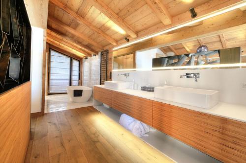 a bathroom with two sinks and a wooden ceiling at Chalet Kuma in Les Houches