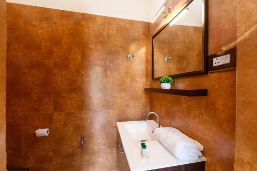 a bathroom with a sink and a mirror at White Lotus Villa by StayJadeJacuzziGames Room in Bengaluru