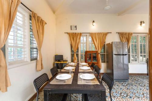 a dining room with a long table and a refrigerator at White Lotus Villa by StayJadeJacuzziGames Room in Bengaluru