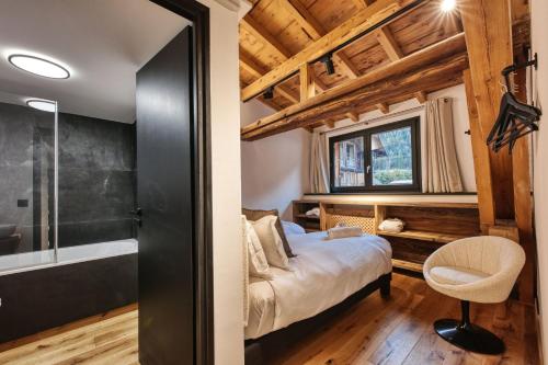 une chambre avec un lit et une baignoire dans une pièce dans l'établissement Le Marti, à Chamonix-Mont-Blanc