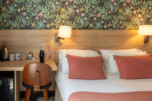 a bedroom with a bed and a desk with two lamps at Hôtel de France, un hôtel AMMI in Nice