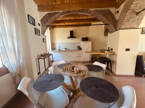 a living room with two tables and chairs and a kitchen at Vitis Verde in Arnasco