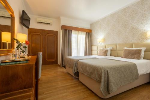 Ένα ή περισσότερα κρεβάτια σε δωμάτιο στο Hotel Sao Jorge Garden