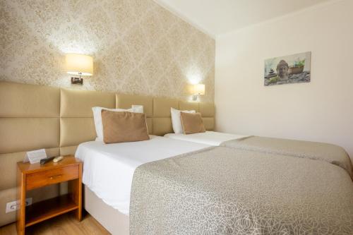 Ένα ή περισσότερα κρεβάτια σε δωμάτιο στο Hotel Sao Jorge Garden