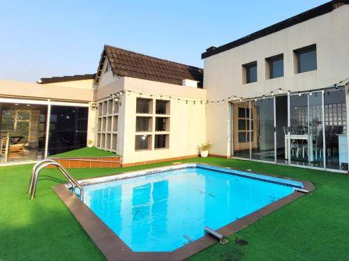 a swimming pool in front of a house at LookOut Ramsgate in Ramsgate