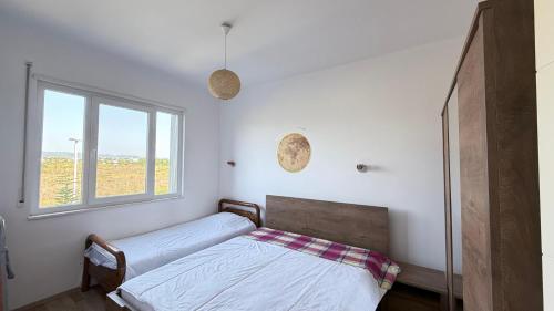 a bedroom with a bed and a window at Vala Mar Apartments by Four C in Hamallë