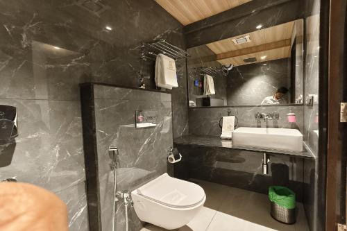 a bathroom with a white toilet and a sink at The Golden Arc in Pune