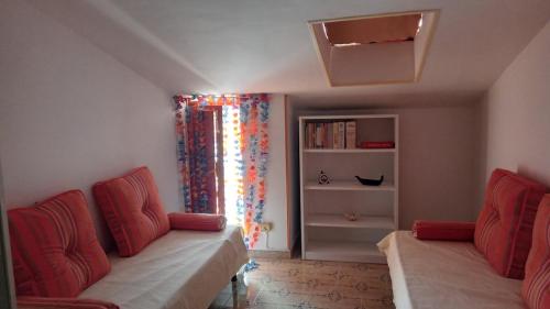 a living room with two red chairs and a window at Appartamento Napodano in Tortora