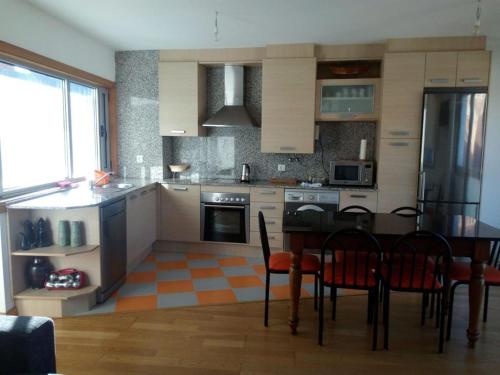 a kitchen with a table and chairs in a room at ATICO PLAYA de VILARIÑO in Aldán