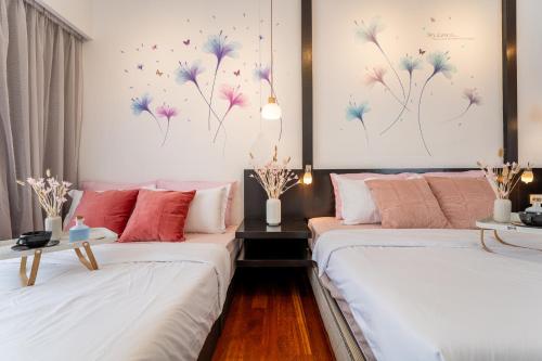 two beds in a room with flowers on the wall at Resort Suites at Pyramid Tower by GL Staycation in Petaling Jaya