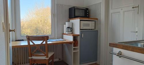 a kitchen with a counter with a microwave and a refrigerator at Huus Am Streek Padd in Cuxhaven