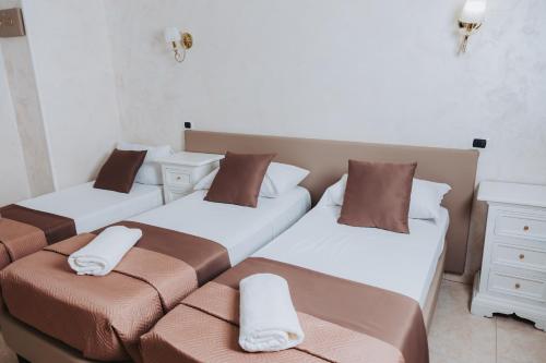 a room with three beds and a couch at Bee Queen Hotel in Marina di Varcaturo
