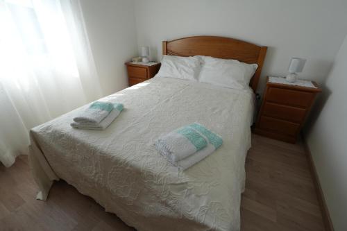 a bedroom with a bed with two towels on it at Casa do Sobral in Ponte de Lima