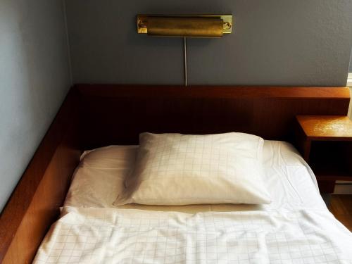 a bed with a white pillow in a room at Hotel Örgryte in Gothenburg
