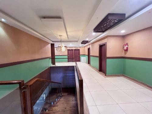 a corridor of a hospital with green and brown walls at FARIS ROOMs in Malappuram