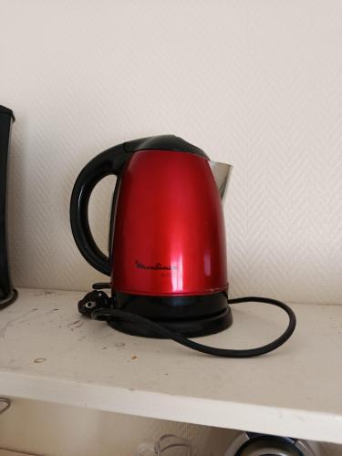 une bouilloire à thé rouge assise sur une étagère dans l'établissement Chez Félix Faure, Chic et élégant, le Havre, Terrasse Vue imprenable, au Havre