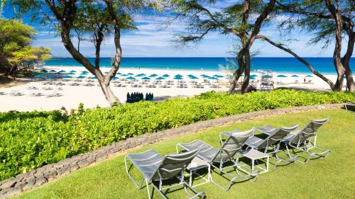 a group of chairs sitting on the grass near the beach at ❤PiH❤ OCEAN BREEZE Panoramic Ocean View Mauna Kea Resort Optional Privileges in Waimea