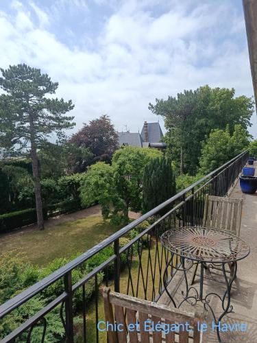 une table et une chaise en fer forgé sur un balcon dans l'établissement Chez Félix Faure, Chic et élégant, le Havre, Terrasse Vue imprenable, au Havre