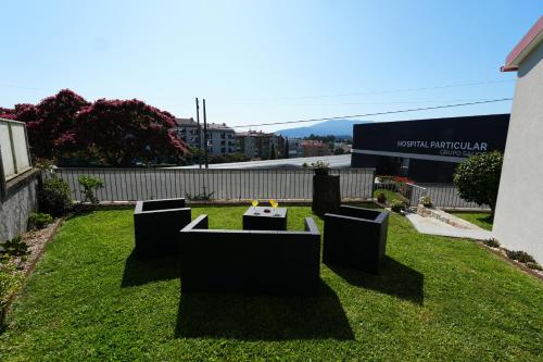 a yard with four chairs and a table in the grass at Casa do Sobral in Ponte de Lima