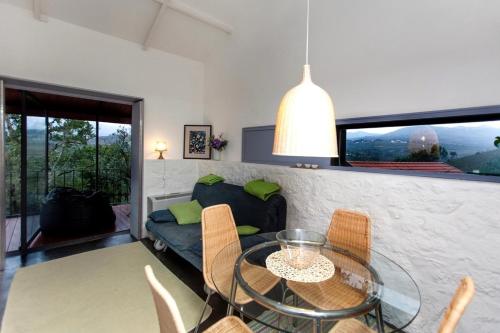 a living room with a glass table and chairs at GoToGeres - Casa da Eira - Sobrenatura in Arcos de Valdevez