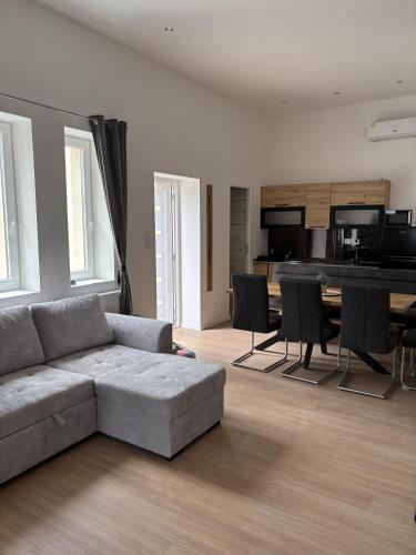 a living room with a couch and a table at Zelia Apartmanház in Siófok
