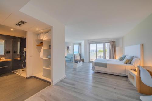 a large bedroom with a bed and a bathroom at Playa Esperanza Resort Affiliated by Meliá in Playa de Muro
