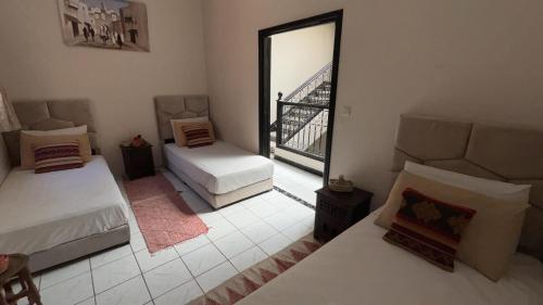a room with two beds and a view of a bridge at Riad Nour Resorts-Riad Nour Travel in Marrakech