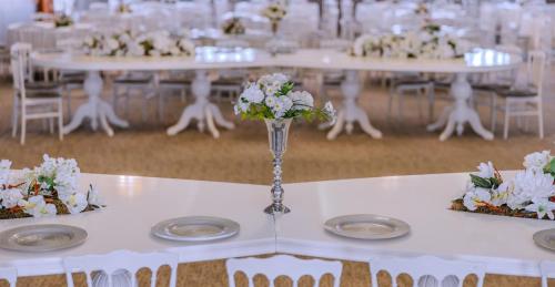 a white table with a vase of flowers on it at Dafne Hotel in Ankara