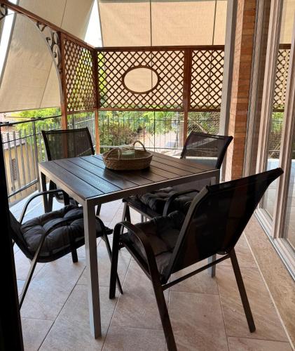 a wooden table and chairs on a screened porch at Twin Homes - Tamerò Estates in Poggio Mirteto