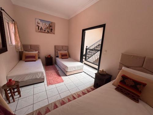 a room with two beds and a view of a bridge at Riad Nour Resorts-Riad Nour Travel in Marrakech