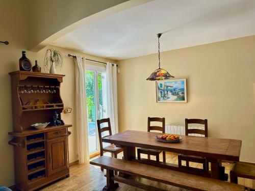 une salle à manger avec une table et des chaises en bois dans l'établissement VILLA avec piscine WIFI parking (Villeneuve Loubet), à Villeneuve-Loubet