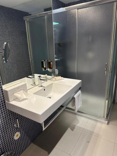 a bathroom with a sink and a shower at Hotel Thermana Park Laško**** Superior in Laško
