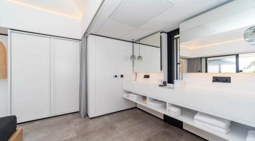 a bathroom with white cabinets and a large mirror at Luxurious Villa with Ocean Views in Pointe Milou in Pointe Milou