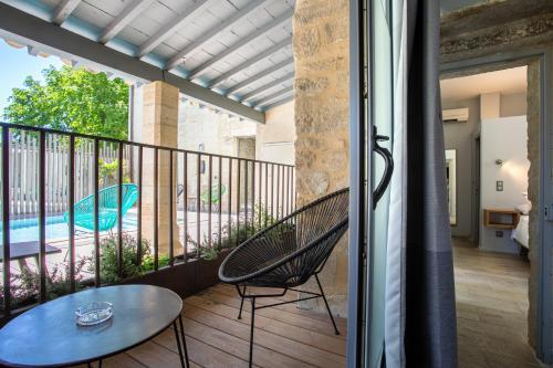 a balcony with a table and chairs and a pool at Boutique Hôtel Entraigues in Uzès