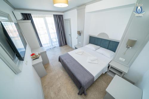 a hotel room with a bed and a television at Daria Boutique Hotel in Eforie Sud