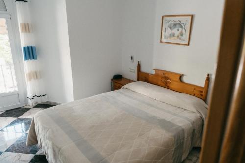 a bedroom with a bed in a white room at Hotel Plaza Manjón in Villanueva del Arzobispo