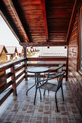 a table and chair on a balcony with a view at Cabana Clujeanului Baile Figa Ciubar in Agrişu de Sus