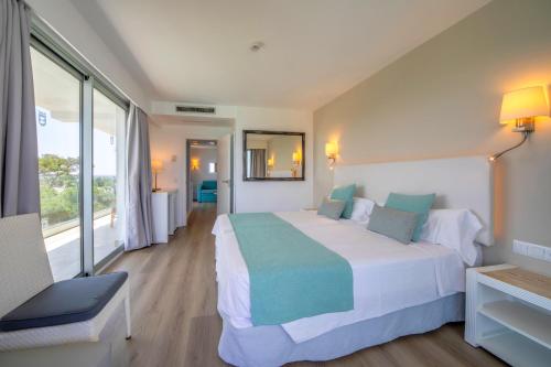 a hotel room with a bed and a window at Playa Esperanza Resort Affiliated by Meliá in Playa de Muro