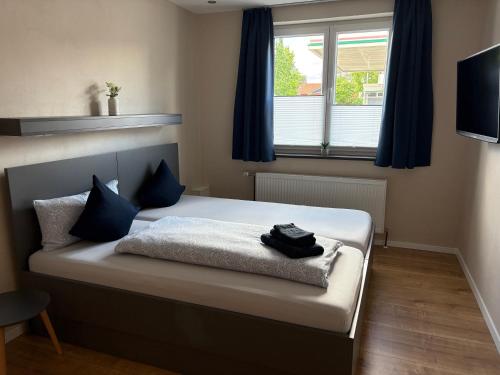 a bedroom with a bed with blue curtains and a window at The Pharmacy Inn in Lemgo
