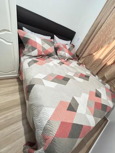 a bed with a quilt and pillows in a bedroom at Micro casa Maju in Cascavel